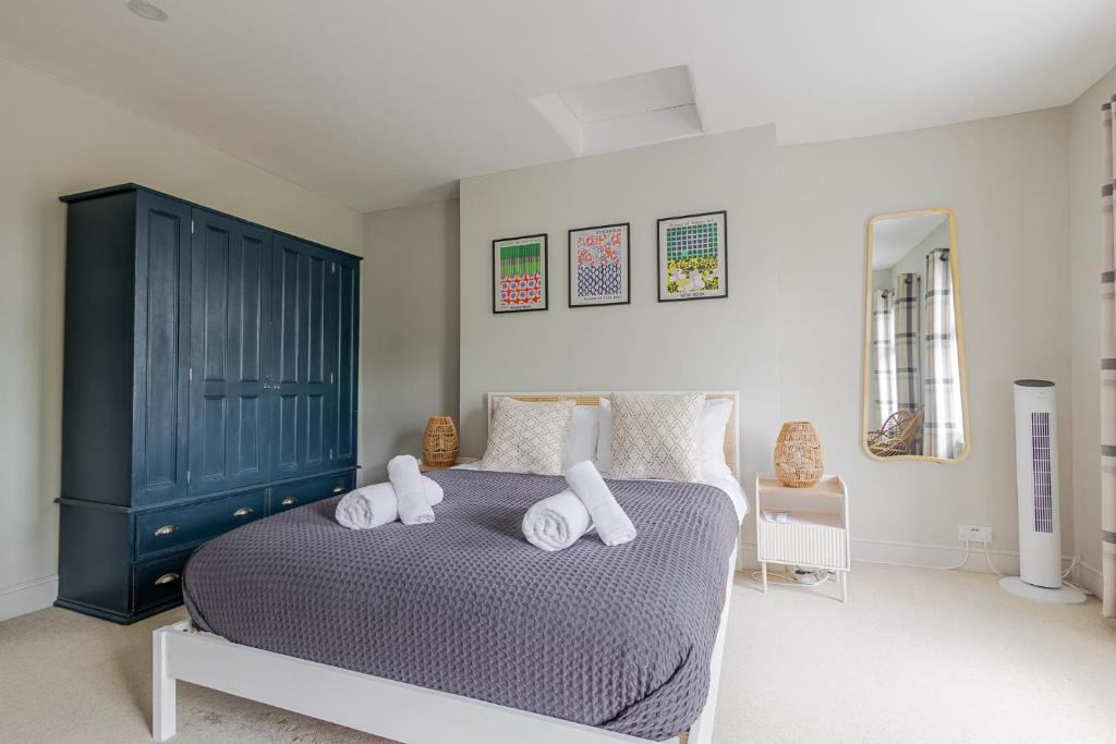 a bedroom with a large bed with towels on it at Stunning Townhouse & Basement in Leamington Spa in Leamington Spa