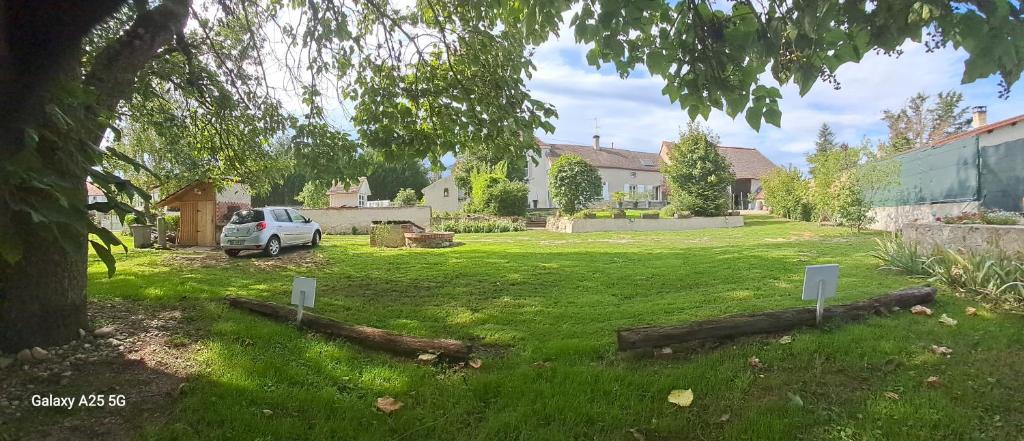 a yard with a car parked in the grass at 15mn de VICHY Le colombier studio climatisation parking privé in Vichy