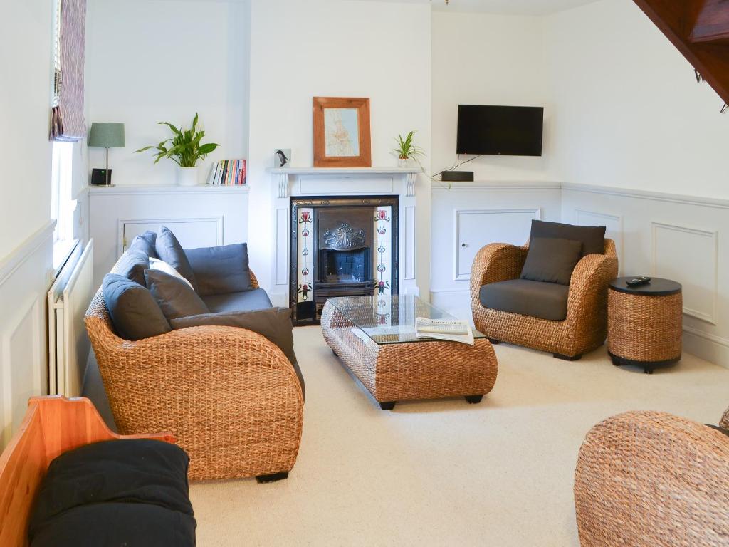 a living room with three couches and a fireplace at Beachcomber Cottage in Woodhorn