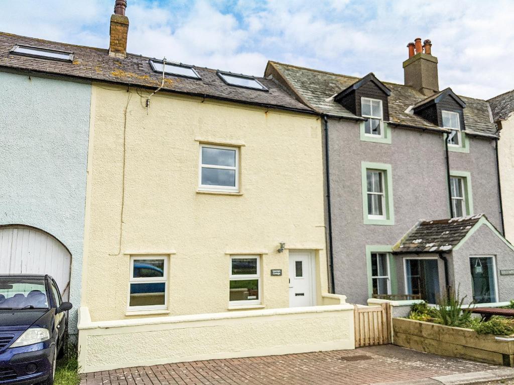 a house with a car parked in front of it at Seascape Cottage in Allonby