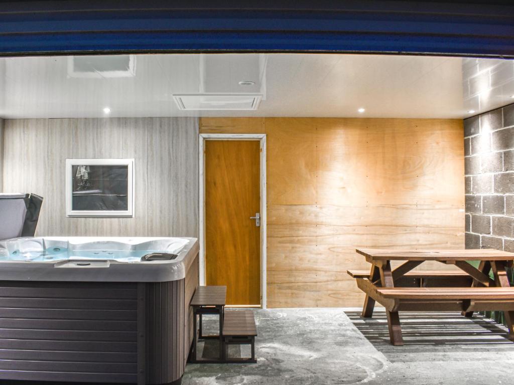 a room with a tub and a picnic table at Stonebank Cottage - Uk35686 in Hunwick