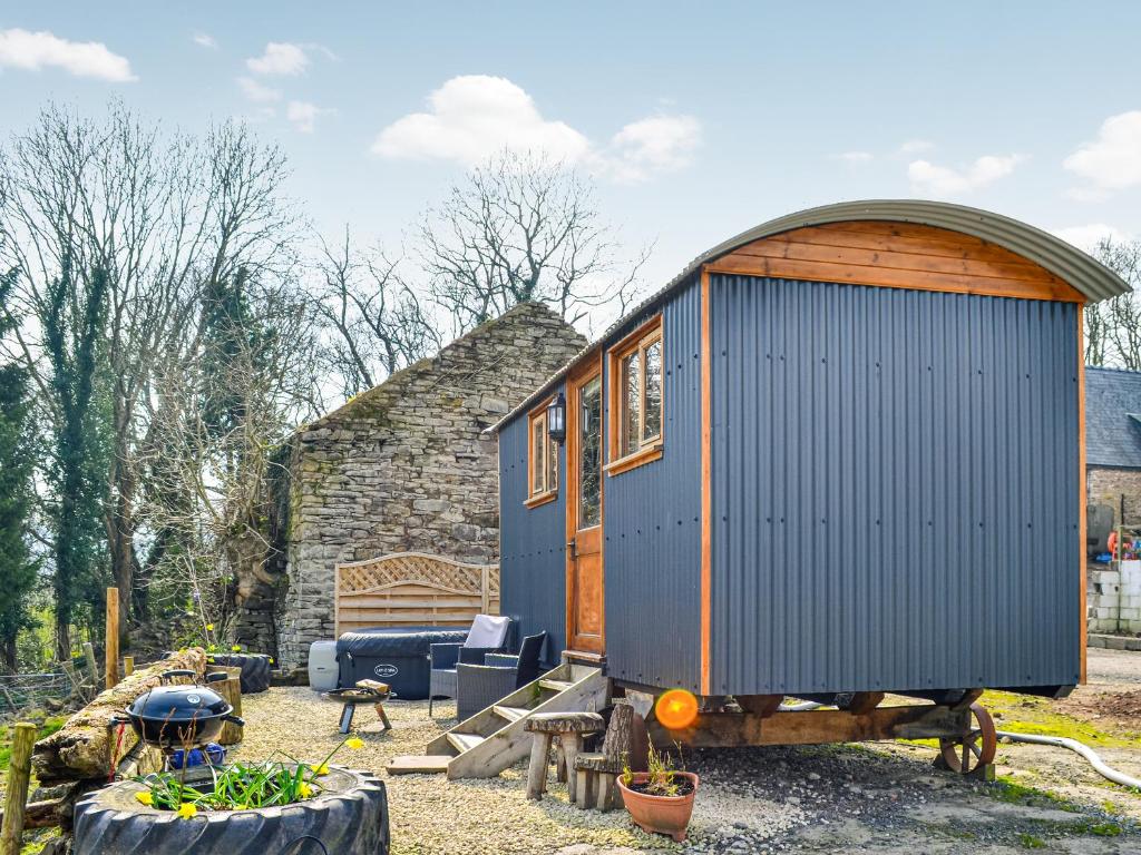 a blue tiny house sitting in a yard at Ty Olwyn Bach - Uk36418 in Talybont
