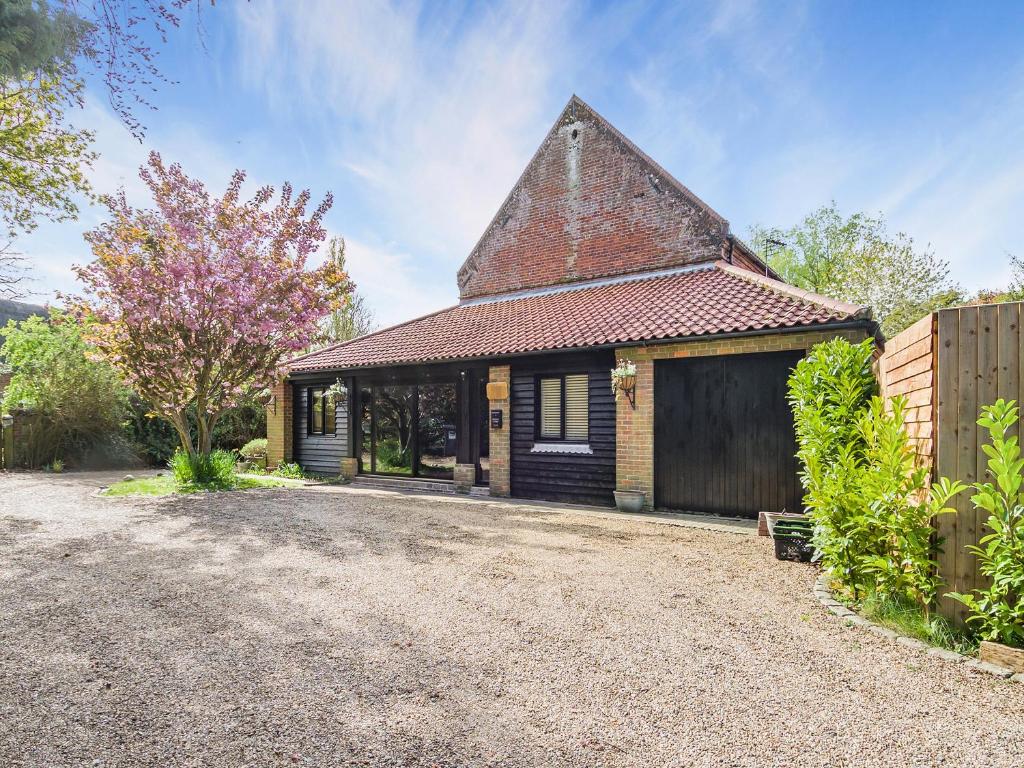 an old house with a gambrel roof and a driveway at Shetland Cottage in Stalham