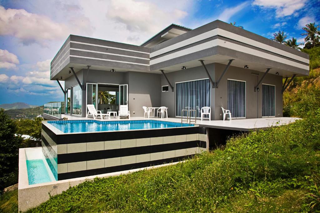 a house with a swimming pool in front of it at Villa Rom Koh Samui in Bophut