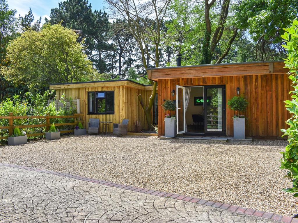 a small wooden building with a patio in front of it at The Retreat in Saint Leonards