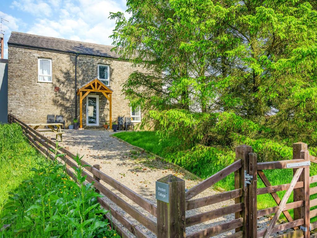 a wooden fence in front of a brick building at Bracken Cottage in Alston