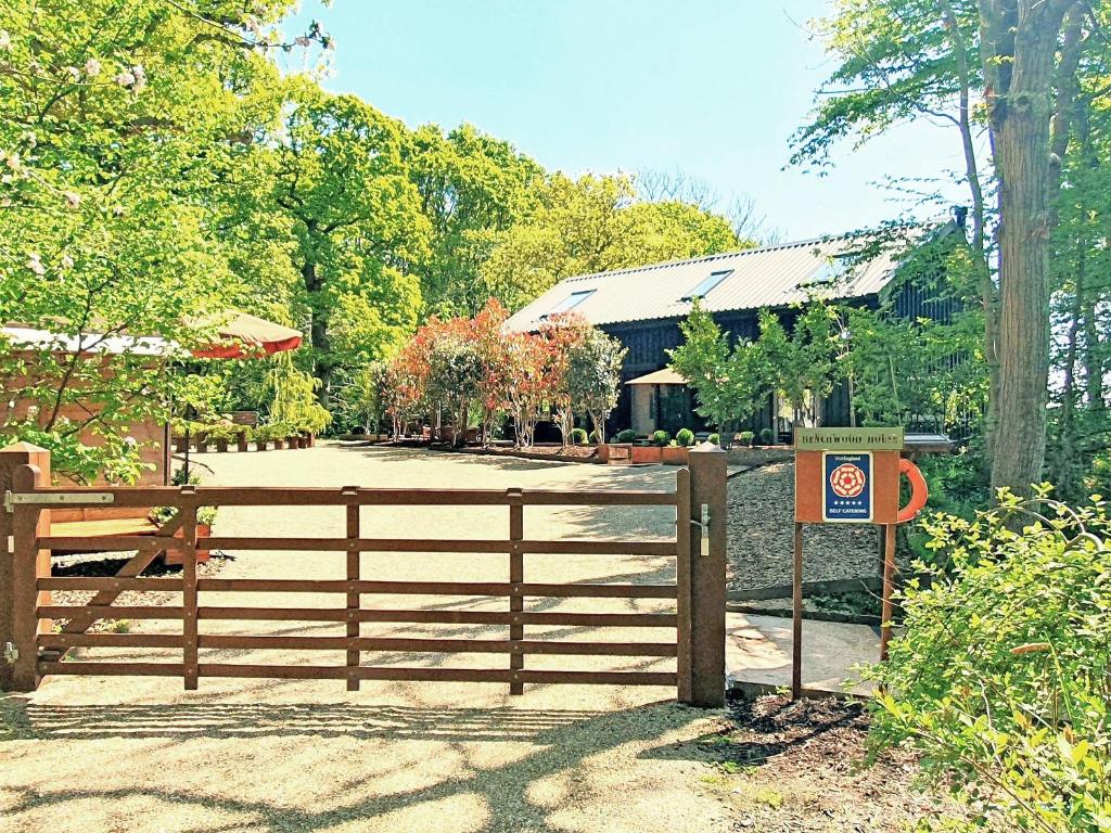 ヘイスティングスにあるBenchwood Houseの家の前の看板を持つ木製の柵