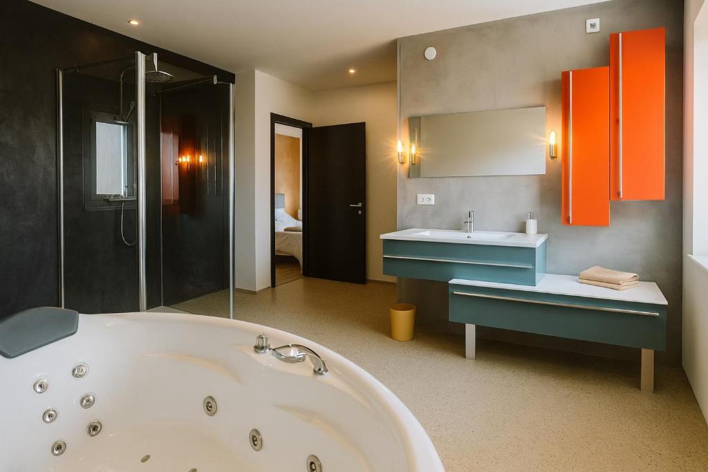 a bathroom with a bath tub and a sink at Villa Évasion Prestige in Brumath