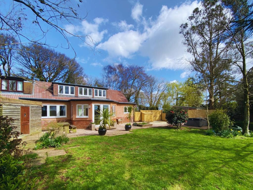 a bedroom house with a garden and a lawn at Wagtails in Milverton