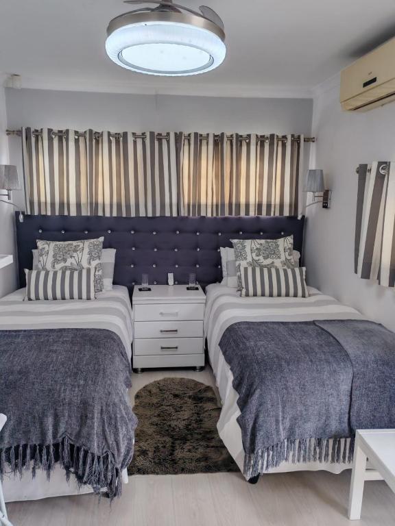 a bedroom with two beds and a blue headboard at Marula Guest House Unit 1 in Durban