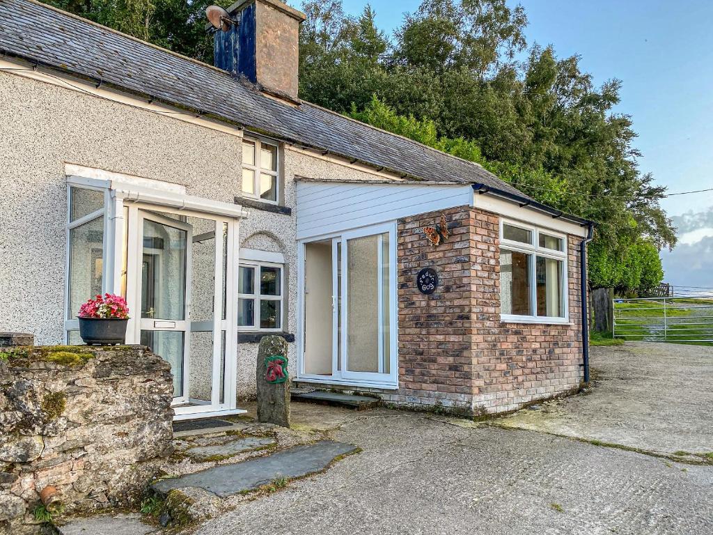 a brick house with a window and a garage at Fedwr Gog Cottage in Llangwm