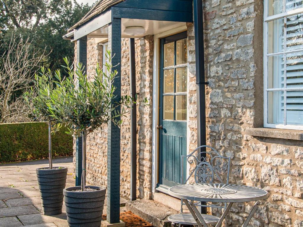 a table and chairs outside of a brick house at The Gatehouse Cottage in Wells