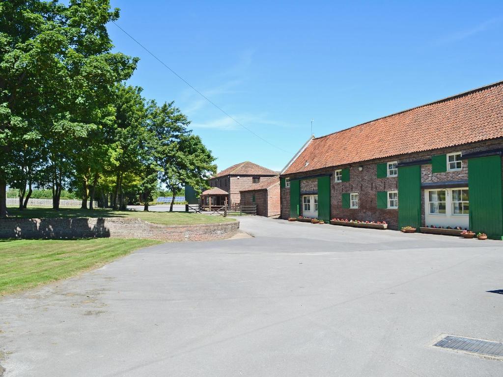 an empty driveway in front of two brick buildings at Clydesdale Cottage in Sewerby