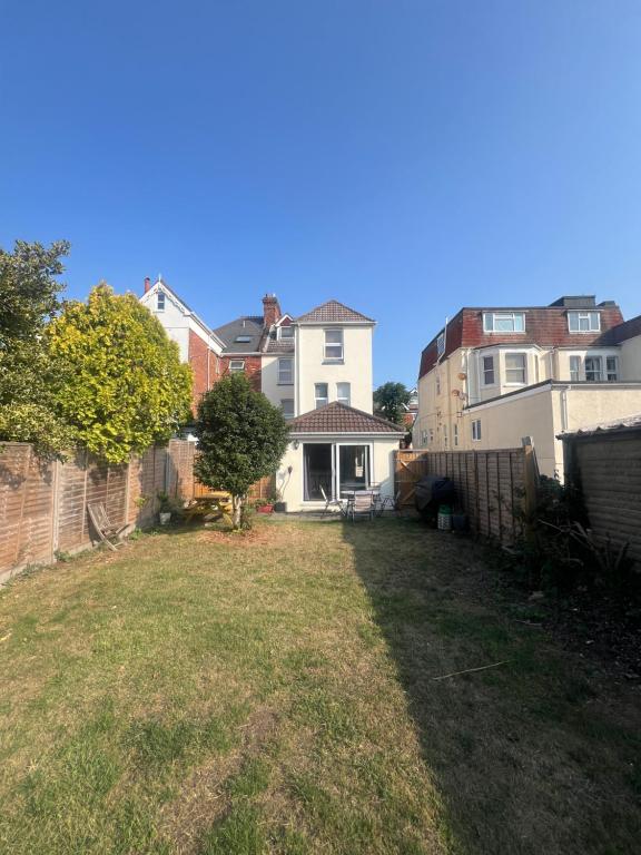 a yard with a fence and a house at Open plan flat with large garden close to beach in Bournemouth