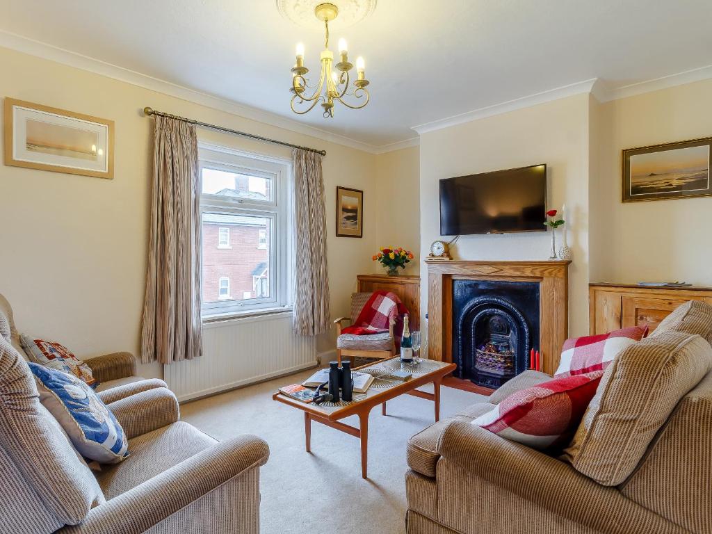 a living room with two couches and a fireplace at Mayflower Cottage in Harwich