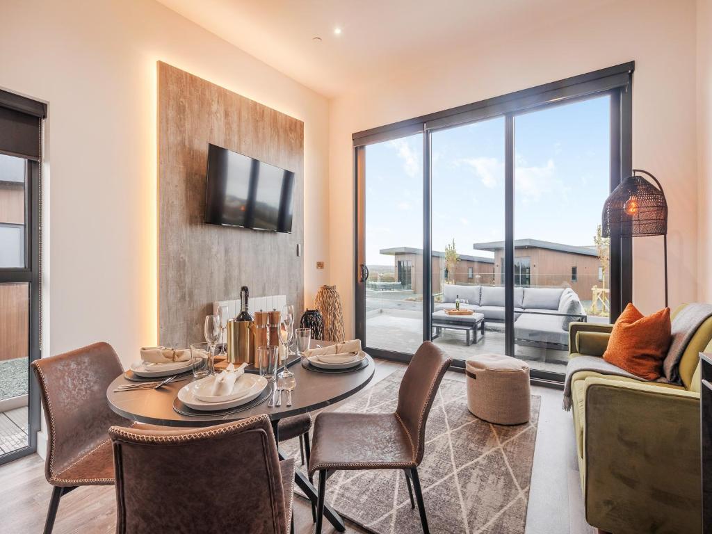 a living room with a table and chairs and a couch at Lodge One - Uk42796 in Llangefni