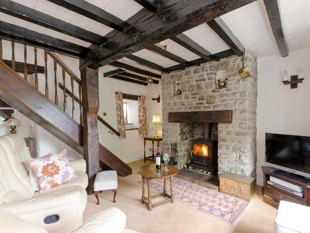 a living room with a fireplace and a stone wall at Lillegarth in Bradwell