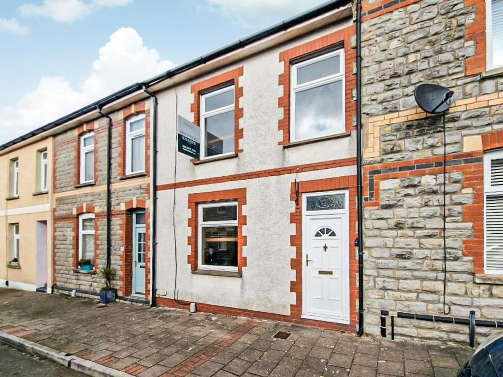 a brick building with a white door and windows at Hysryb Cottage in Cardiff