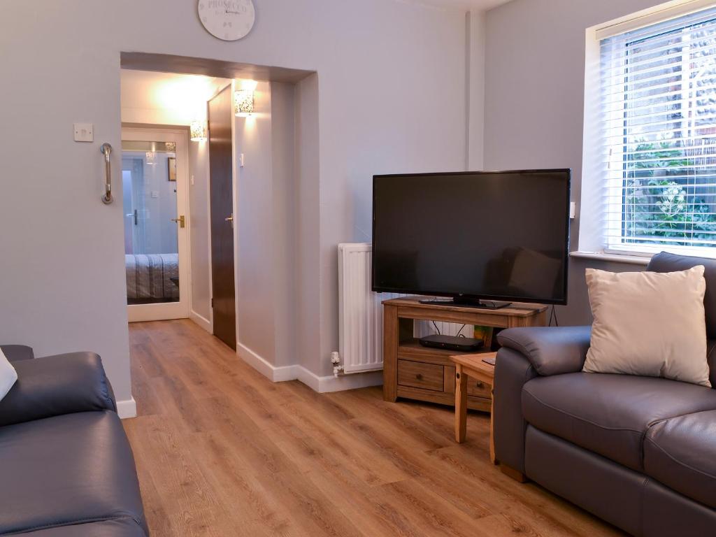a living room with a flat screen tv and a couch at Fisherman's Cottage in Sheringham