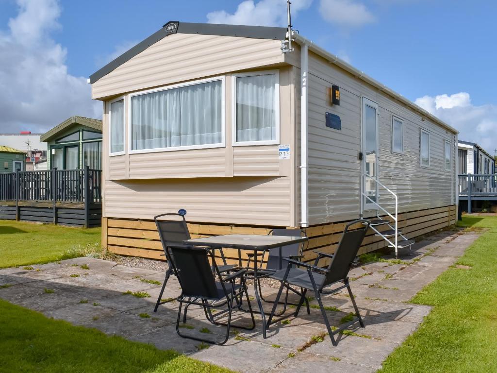 a table and chairs in front of a caravan at Cara in Lancaster