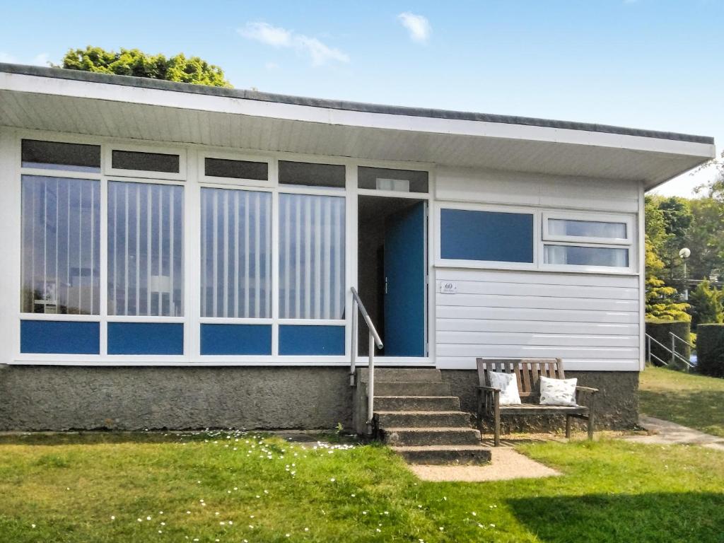 una casa con una puerta azul y un banco en Blue Skies - 30260, en Cromer