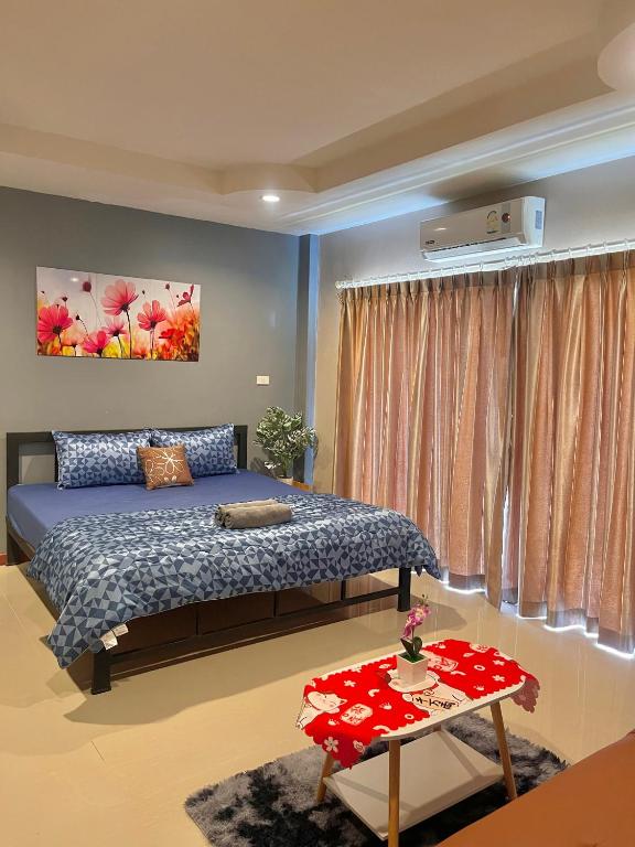 a bedroom with a bed and a table at Pluemjai mansion in Kathu