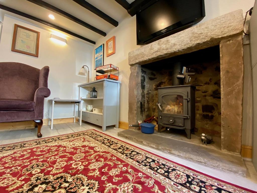 a living room with a fireplace and a couch at T'owd Man's Cottage in Bonsall
