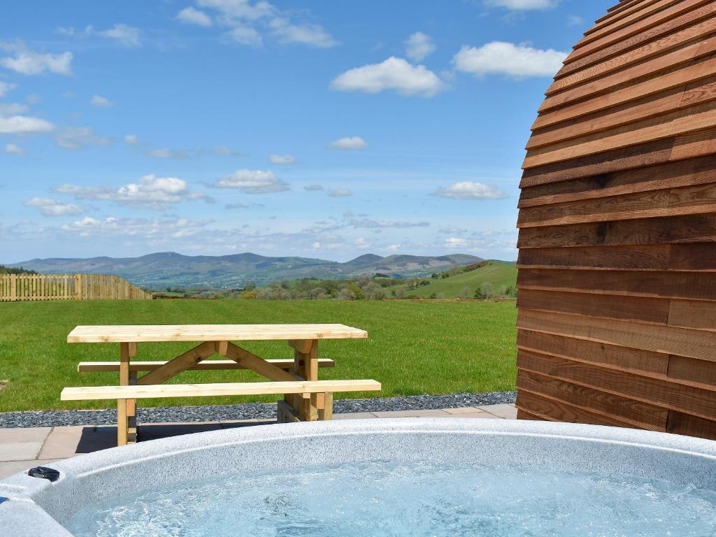 a picnic table and a bench next to a hot tub at Foty - Uk2781 in Llanelidan