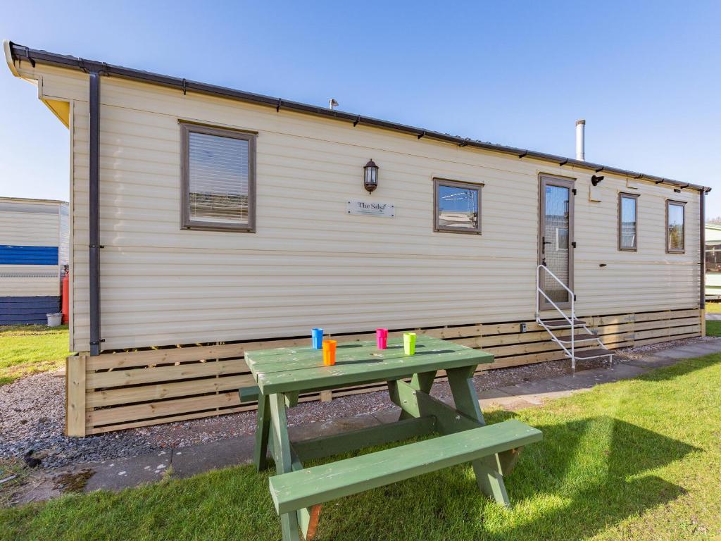 a green picnic table in front of a house at Vanhalla in Morecambe