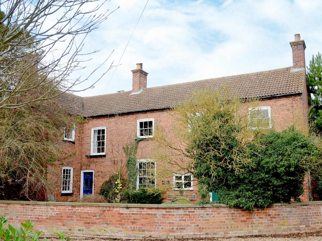 a large red brick house with a brick wall at Abbott's Farm in Horbling