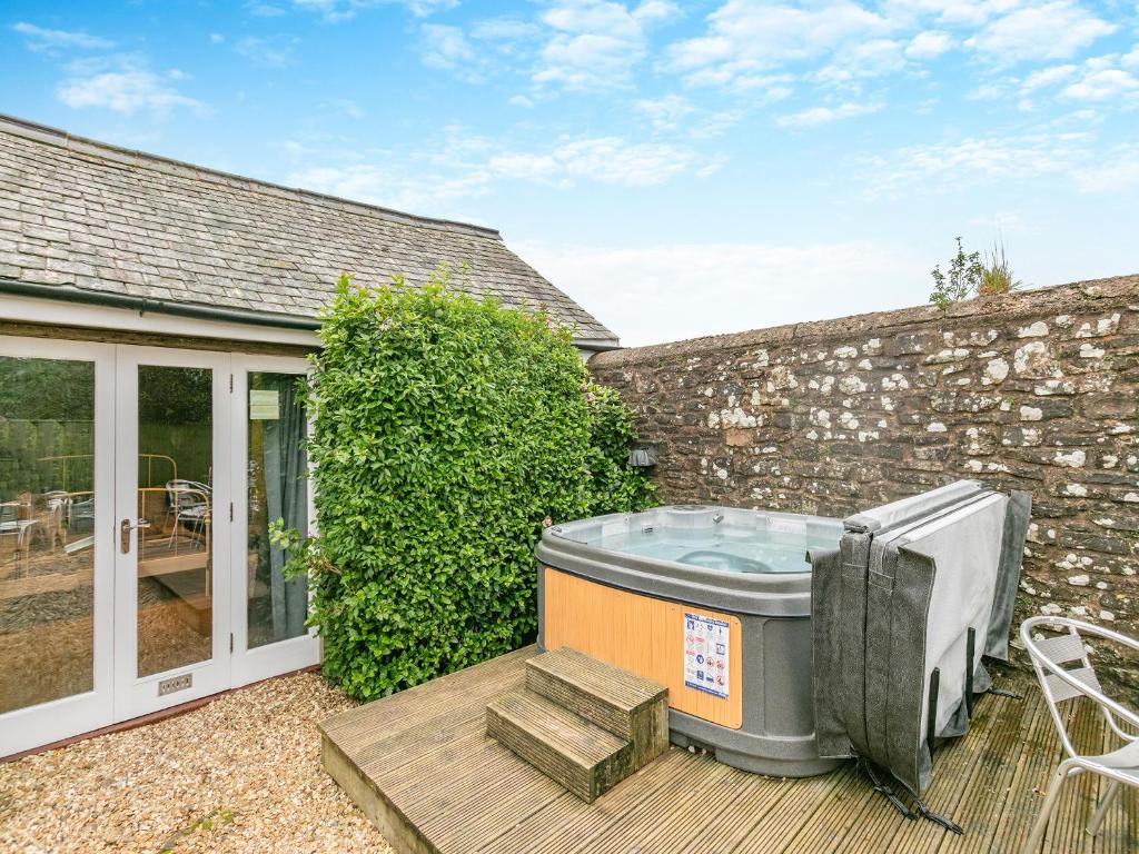 a hot tub on a deck next to a house at North Lake Chapel in West Worlington