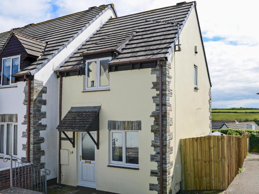 ein weißes Haus mit einem schwarzen Dach in der Unterkunft The Yellow House in Padstow