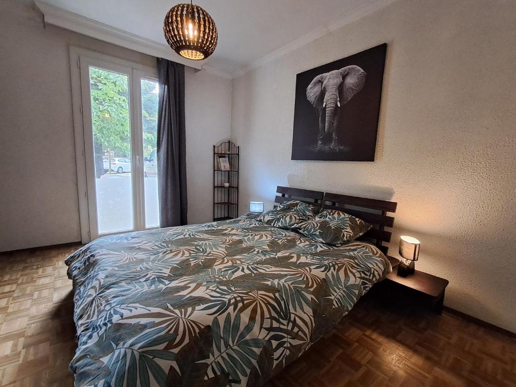 a bedroom with a bed with an elephant picture on the wall at Le gîte de l'Ecureuil - 4 personnes in Donges