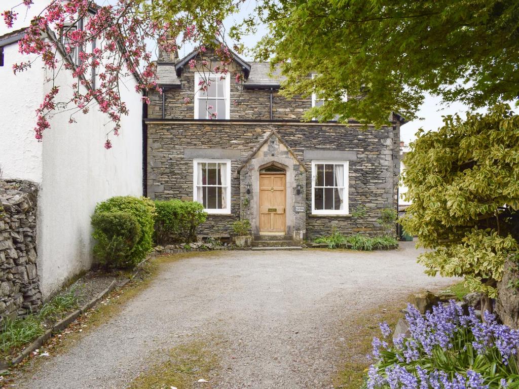 an old stone house with a large driveway at Yew Tree Cottage in Windermere