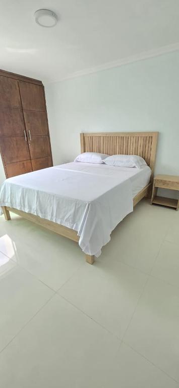 a bedroom with a bed and a wooden dresser at Apartamento amoblado Murillo in Barranquilla