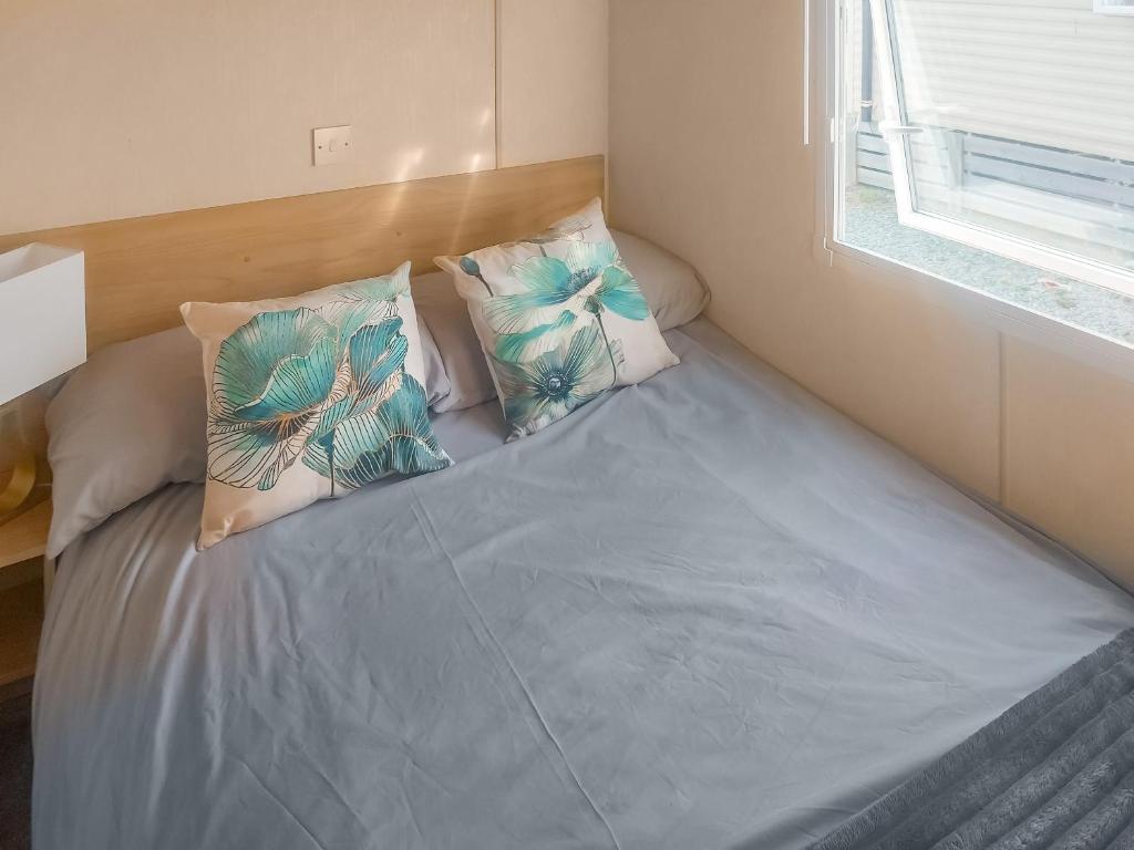 a bed with blue sheets and pillows in a room at Marni's Seaview in Heysham