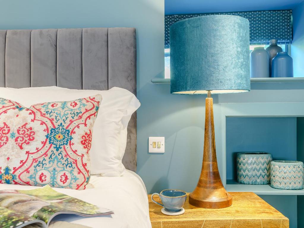 a lamp sitting on a table next to a bed at Frenchgate Mews in Richmond