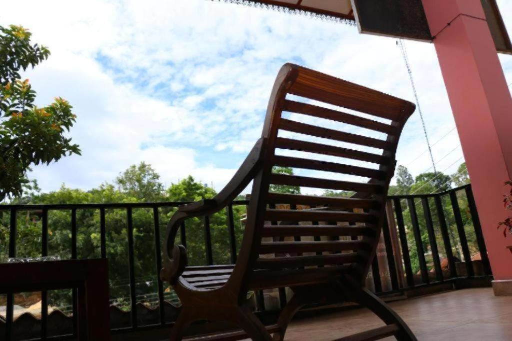 a wooden rocking chair sitting on a porch at Little heaven guest in Ella