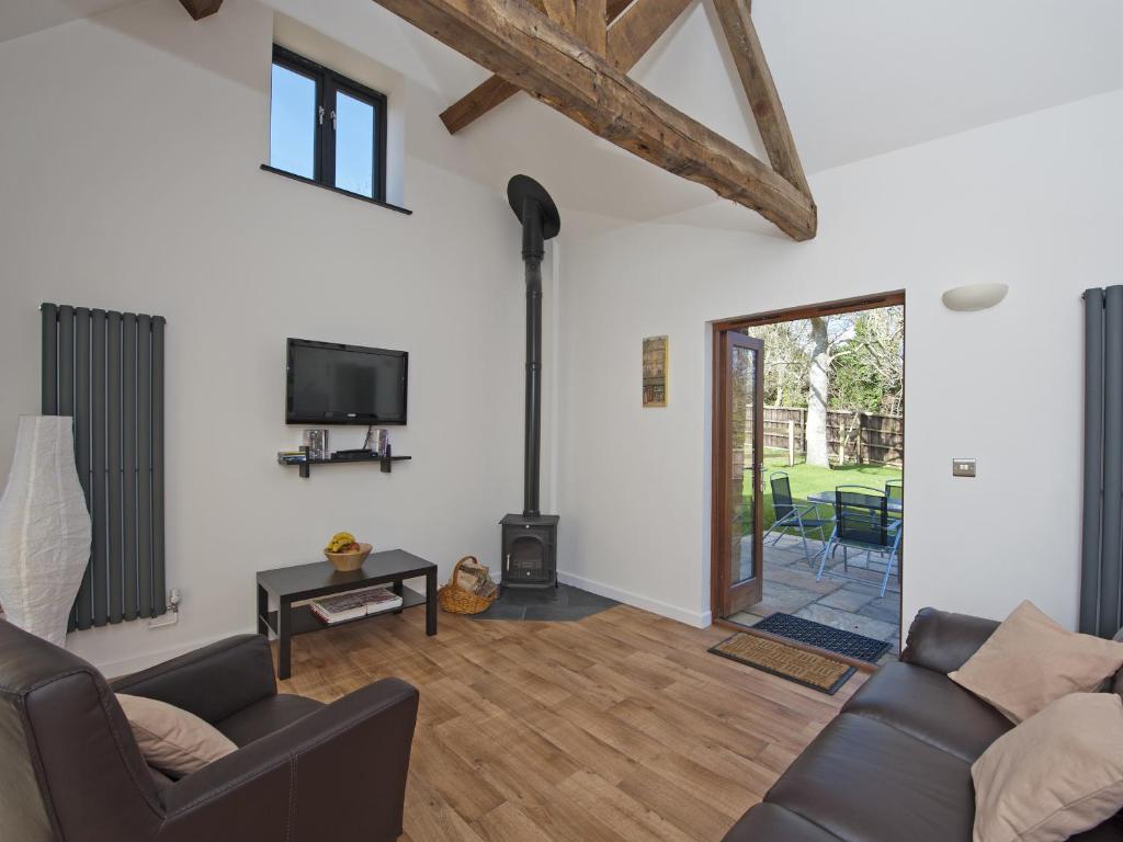 a living room with a couch and a fireplace at Oak Barn - Fernhill Farm in Wootton Bridge