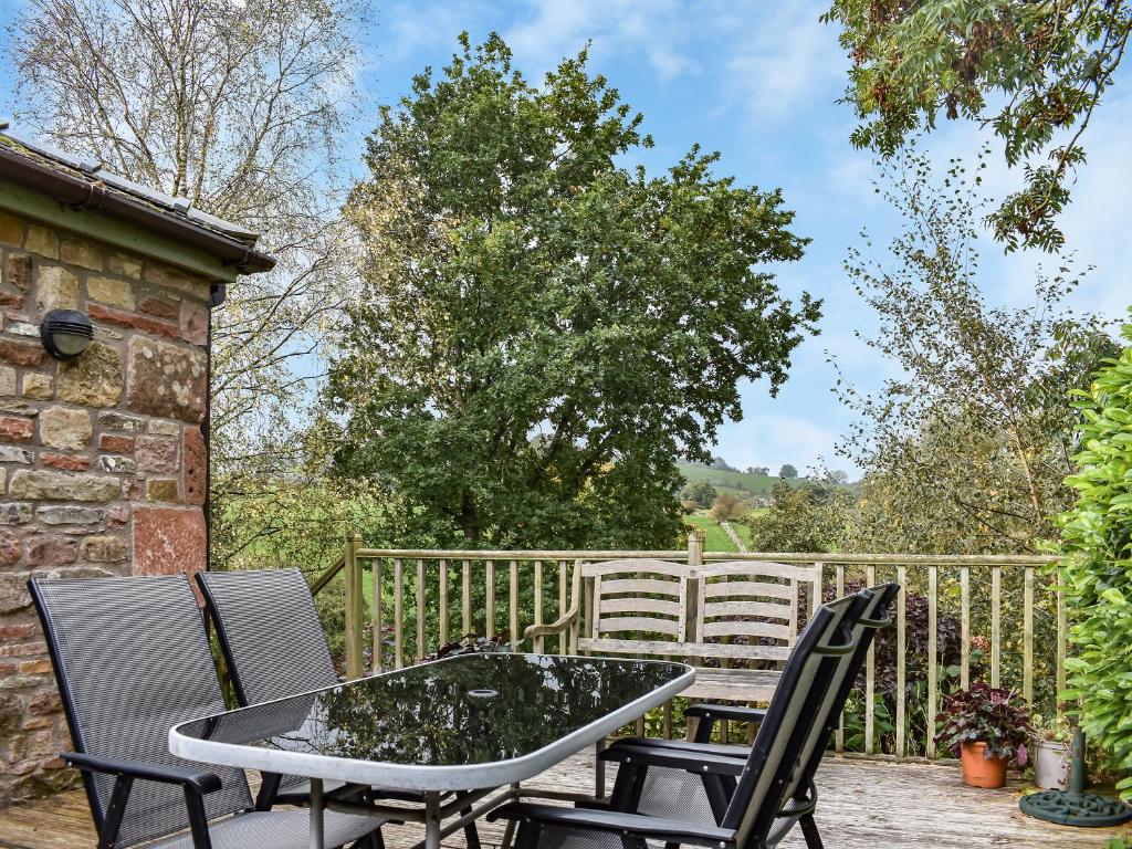 a patio with a table and chairs and a fence at Riverbank Cottage in Pooley Bridge