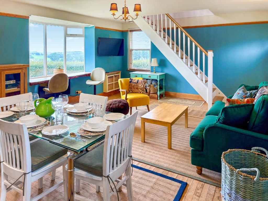 ein Wohnzimmer mit einem Tisch und einer grünen Couch in der Unterkunft The Cottage At Mains House in Tain