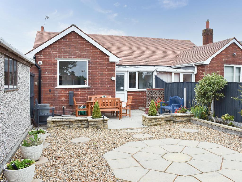 a backyard with a brick house with a patio at Berwick Lodge in Thornton