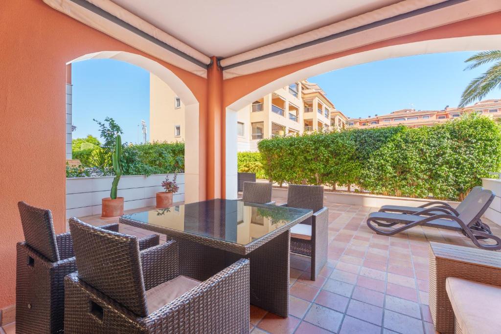 an outdoor patio with a table and chairs at Hogar Brisa de las Marinas acogedor apartamento con amplia terraza y acceso directo a las piscinas-Comfortable apartment with spacious terrace and direct pool access in Denia
