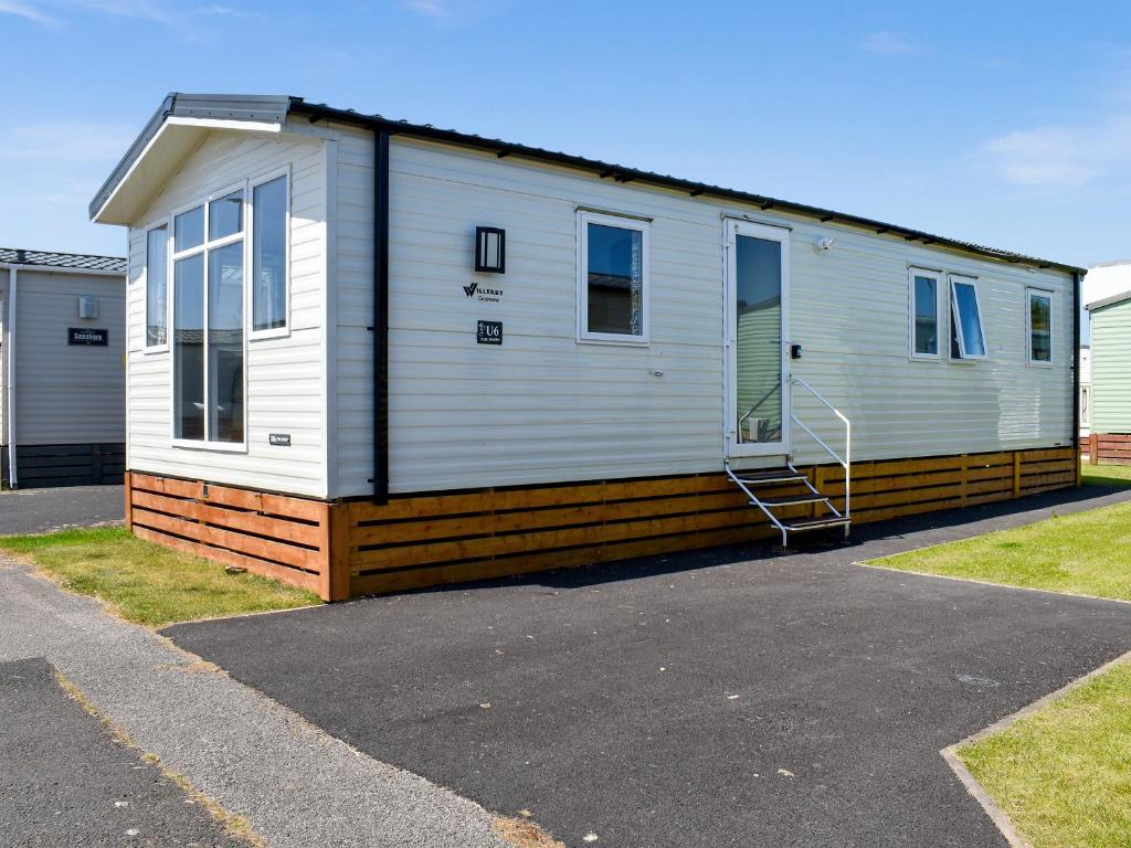 a mobile home is parked in a parking lot at The Moon in Heysham