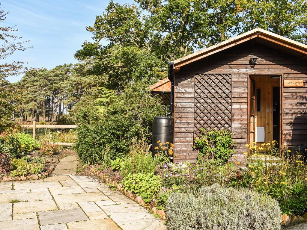 a small wooden shed in a garden at The Cottage At Dockens Water in Fritham