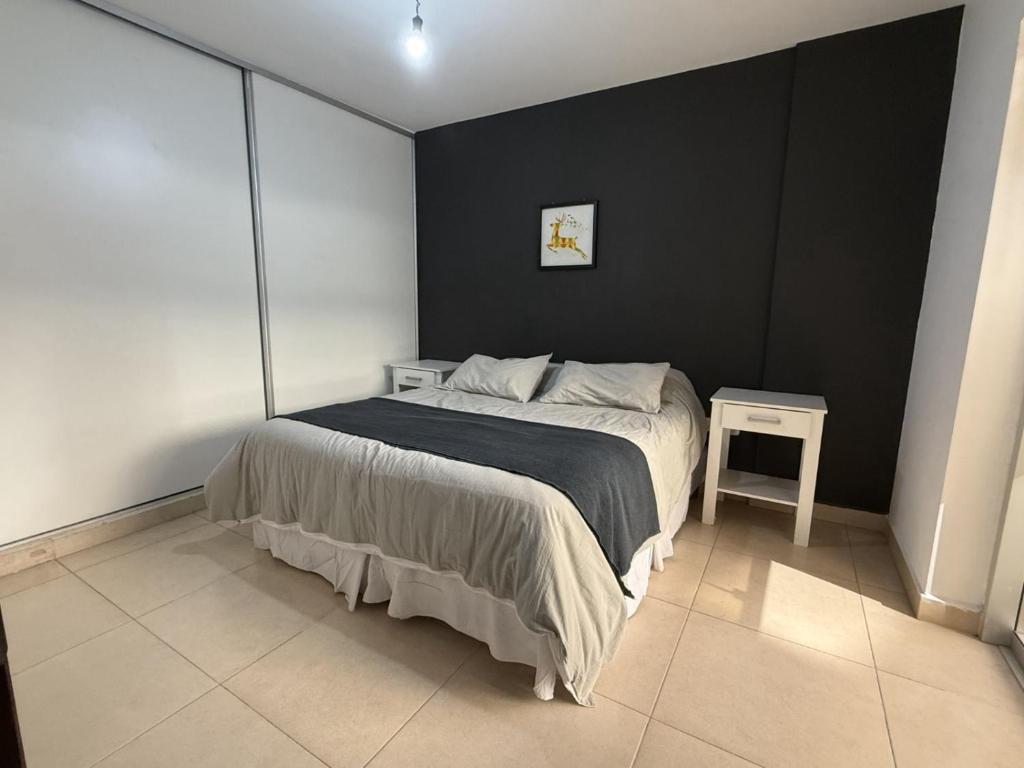 a bedroom with a bed and a side table at Moderno y funcional Dpto cerca del casco histórico de Salta in Salta