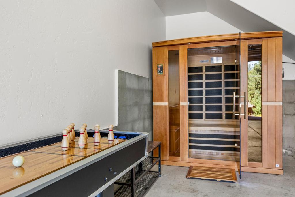 a room with a ping pong table in front of a door at Nakai Trail 4-br A-frame Firepit Game Rm Sauna in Mountainaire