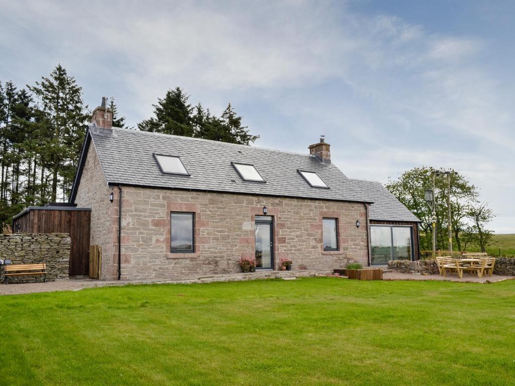 a brick house with windows and a grass yard at Greenford Farm in Newtyle
