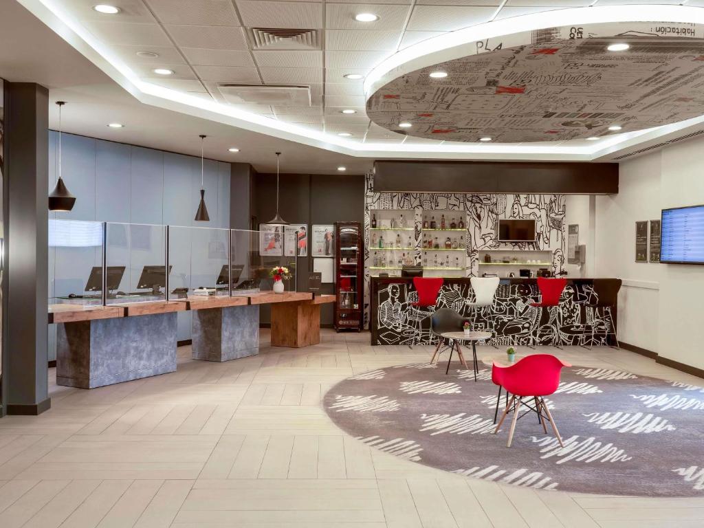an office lobby with red chairs and a desk at ibis Ankara Airport Hotel in Ankara
