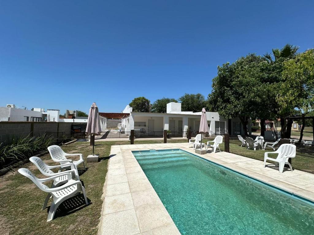 a swimming pool with lawn chairs and a group at Monoambiente acogedor cerca de playa en Miramar in Miramar